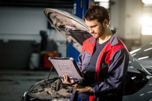 Examining car engine-NOLA Automotive Repairs